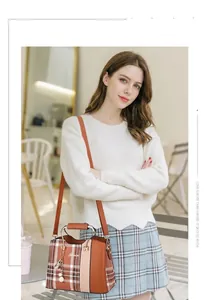 Detail of checkered patchwork handbag with metal handles and adjustable leather strap