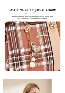 Detail of brown plaid tote with metal flower pendant and polished brand logo plaque