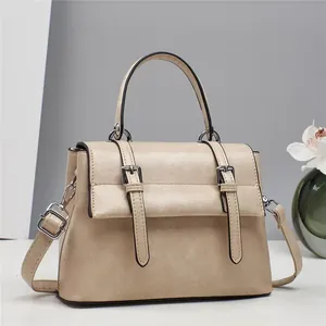 Detailed view of beige vintage satchel showing leather texture and buckle straps