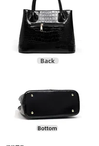Detail view of the black crocodile pattern handbag showing back pocket and bottom studs