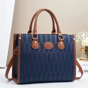 Large blue and brown color-block leather tote bag with gold hardware and top handles