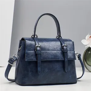 Retro dark blue messenger bag with dual buckle straps and textured leather finish