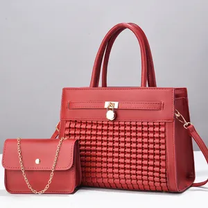 Détail du sac à main rouge tressé avec cadenas doré et pochette à bandoulière assortie