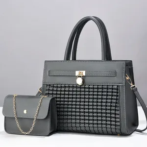 Détail du sac cabas gris avec texture tressée, fermoir doré et pochette à chaîne assortie