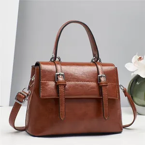Vintage brown leather satchel with top handle and crossbody strap for women