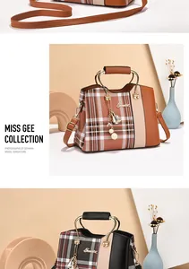 Detail of plaid tote bag featuring metal ring handles and decorative pearl tassel charm