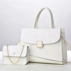 Detalle del bolso blanco con textura de cocodrilo y bolso pequeño con cadena de oro