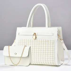 Vue détaillée du grand sac blanc tressé et de sa petite pochette avec chaîne dorée