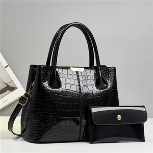 Black crocodile embossed tote and pouch set with polished patent finish and gold hardware