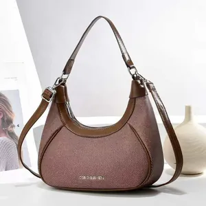 Detail of hobo crescent bag in brown and beige woven fabric with leather strap