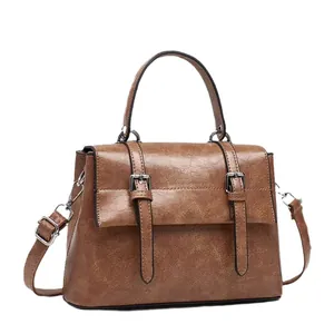 Vintage brown messenger bag with top handle and adjustable strap in matte faux leather