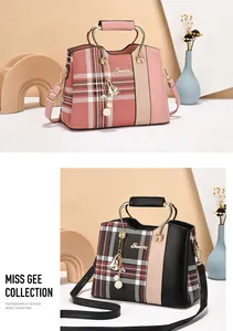Detail of checkered tote bags with metal handles, contrast stitching and bell pendant