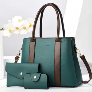 Detailed view of the three-piece handbag set featuring litchi grain texture and gold hardware