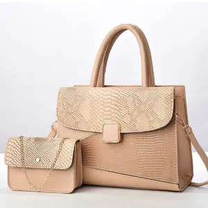 Detalle del conjunto de bolso beige con solapa de piel de serpiente y cadena dorada