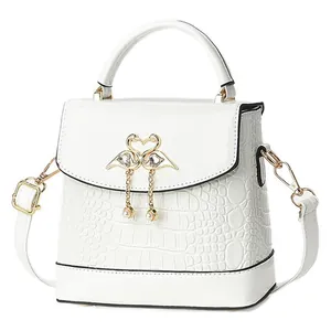 Mini sac à main blanc motif crocodile avec ornement cœur doré et détails de pompons perles