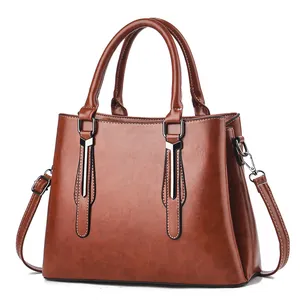 Classic retro caramel brown faux leather handbag with wide handles and shoulder strap