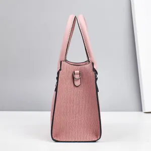 Detail der rosa Handtasche mit vertikaler Plissee-Textur und silberner D-Ring-Befestigung