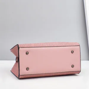 Detailansicht der rosa Handtasche mit vier schützenden Metallfüßen am Taschenboden