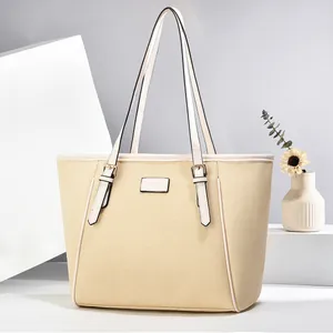 Detail of woven beige tote bag with Fashion leather patch and gold metal buckles