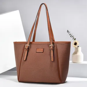 Classic brown tote bag with textured fabric and leather trim displayed on a geometric stand