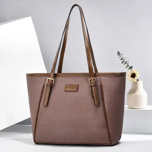 Brown textured woven tote bag with dark leather trim and golden metal hardware