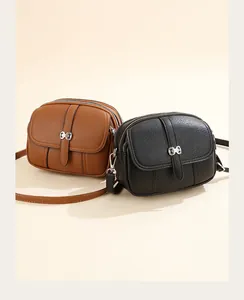 Close-up of small round crossbody bags with lychee texture and metal bow clasp