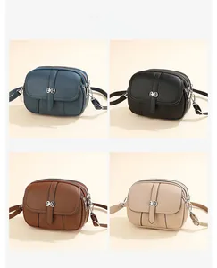 Detail view of four textured leather crossbody bags with triple zippers and bow buckle