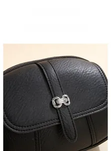 Close-up of black lychee leather bag featuring vintage silver double-ring hardware and stitching