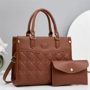 Détail du cabas marron en similicuir matelassé et pochette assortie avec boucles dorées