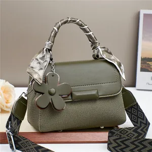Sac à main vert foncé en cuir et tissu tissé avec pendentif fleur et sangle