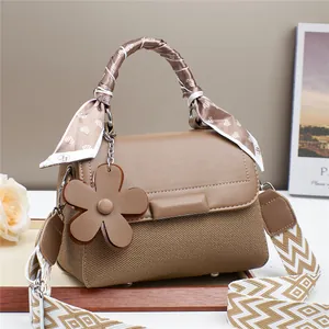 Sac à main kaki avec texture tissée, pendentif floral et foulard décoratif en soie