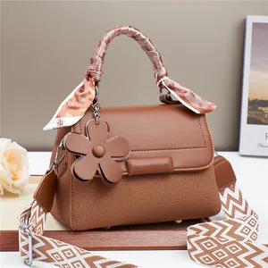 Sac à main marron en maille avec breloque fleur et bandoulière à motifs géométriques
