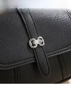 Detail show of premium black leather texture and silver metal twist knot buckle on bag