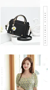 Detail of black PU leather saddle bag with white stitching and daisy charm detail
