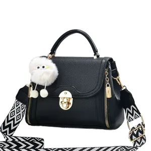 Sac à main noir en cuir grainé avec détails dorés et bandoulière tissée géométrique