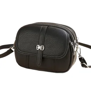 Classic black crossbody round bag with pebble leather texture and silver hardware details
