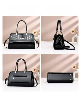 Detail views of black glossy leather handbag with camellia ornament and studded bottom