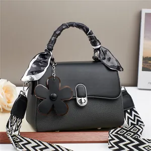 Elegant black handbag for women with silk scarf handle and floral charm accessory