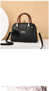Macro shot of black litchi leather shell bag with tortoiseshell handle and gold clasp