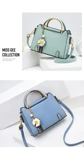 Detail of round metal handles and daisy charm on mint green and sky blue handbags