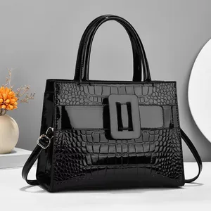 Detail of glossy crocodile-embossed faux leather handbag with metallic square buckle