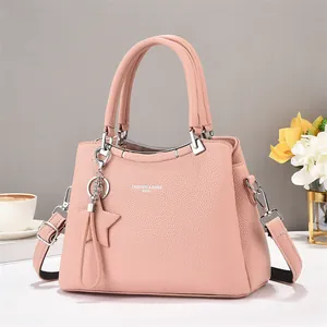 Pale pink lychee grain leather tote bag with round metal handles and star charm accessory