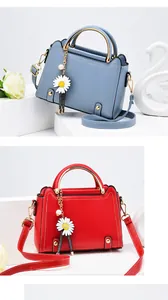 Detail of elegant handbag with daisy pendant charm and premium contrast stitching