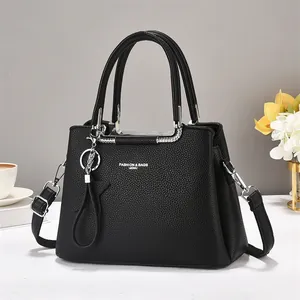Minimalist black pebbled leather tote bag with silver hardware and star charm detail