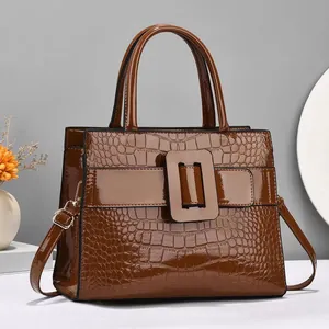 Glossy brown crocodile pattern handbag with large square buckle and adjustable strap