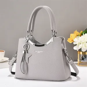 Macro shot of gray textured leather handbag with gold metal hardware and star pendant
