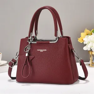 Burgundy litchi leather tote bag with silver hardware and star charm accessory