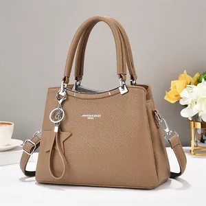 Close-up of brown litchi pattern leather tote with star charm and metallic hooks