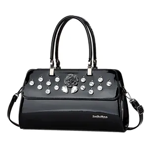 Elegant black patent leather handbag with sparkling rhinestones and floral decoration