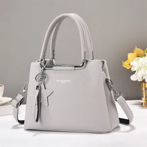 Detail of grey lychee leather texture on tote bag with silver hardware and star charm